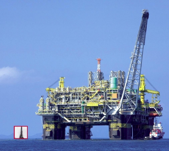 Platforma wiertnicza na tle dawnej wieży wiertniczej