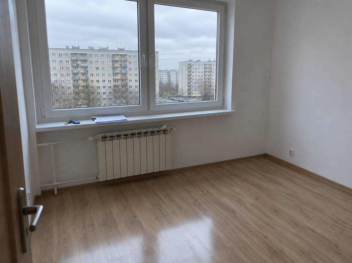 Pusty pokój w mieszkaniu w bloku z kluczami i spiętymi dokumentami na parapecie